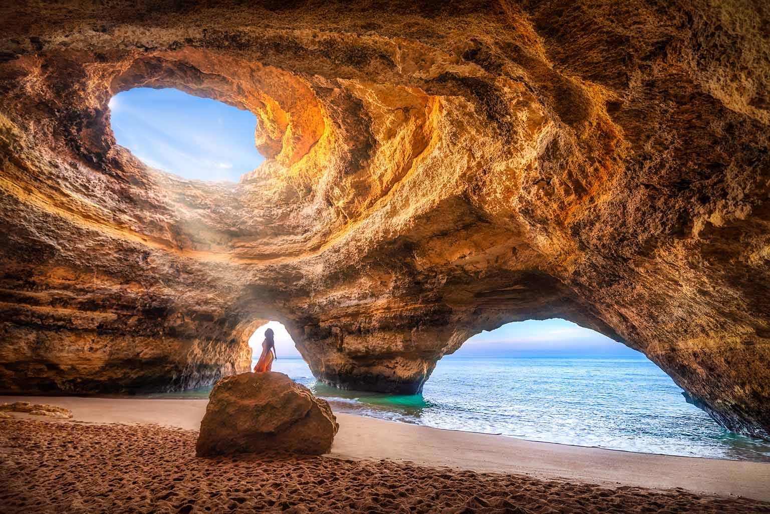 sunlight shining through the opening of as cave in the Algarve, Portugal.