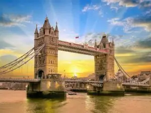 Tower Bridge in London with the sun rising between the two towers.