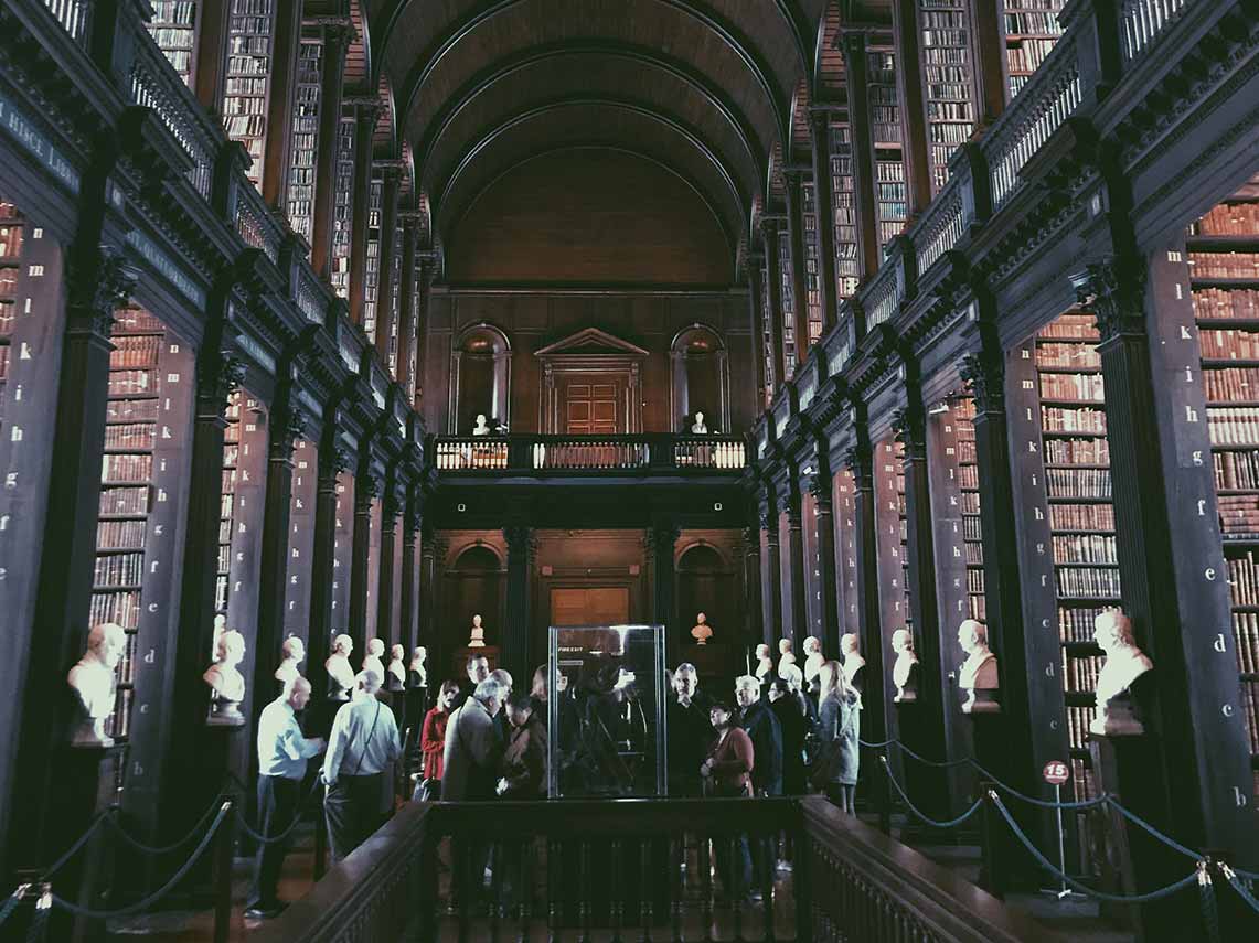 inside the halls of trinity college in dublin with people on private tour