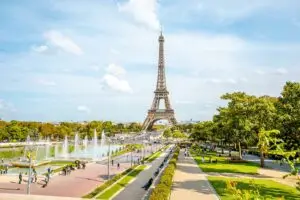 Vibrant view of the Eiffel Tower in Paris with bustling tourists and flowing fountains on a sunny day, perfect for exploring French landmarks and culture.
