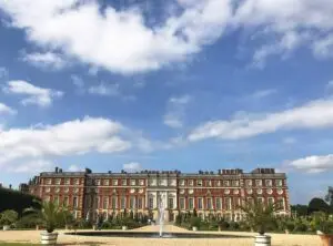 Hampton Court Palace with fountain and garden on a sunny day, a historic royal building in England, perfect for cultural tourism