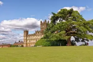 Visitors enjoying a sunny day at Highclere Castle in England, famous for its majestic architecture and lush green grounds.