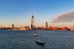 Twilight view of Spinnaker Tower and the vibrant harbor area in Portsmouth, highlighting the dynamic waterfront and architectural beauty during a sunny evening on England's South Coast.