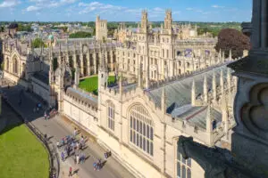 Aerial view of the historic All Souls College at the University of Oxford, showcasing its intricate Gothic architecture and bustling courtyard with visitors.