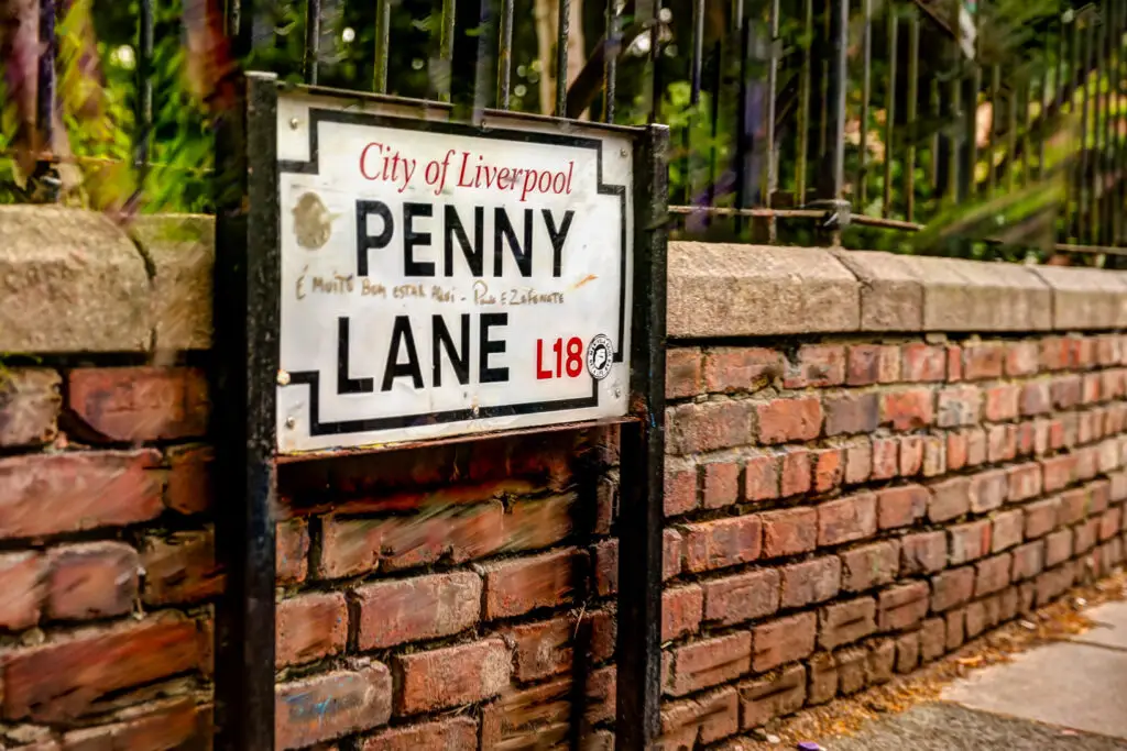 Penny Lane street sign on brick wall in Liverpool, UK, a famous tourist attraction related to The Beatles.