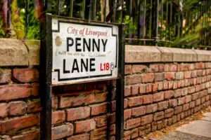 Penny Lane street sign on brick wall in Liverpool, UK, a famous tourist attraction related to The Beatles.