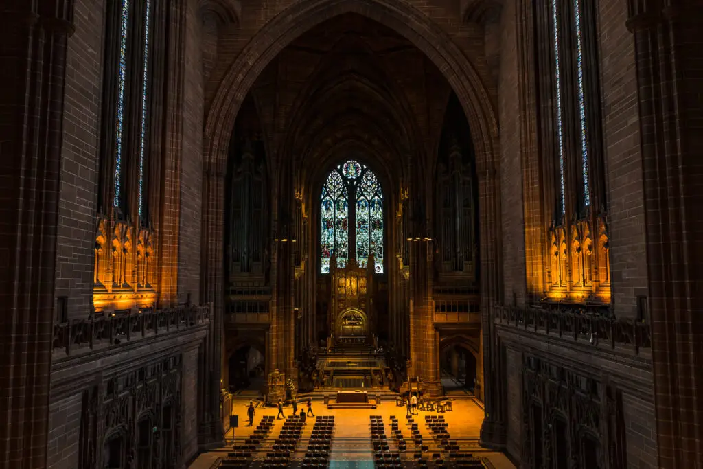 Interior view of the Anglican Cathedral in Liverpool, showcasing the majestic architecture, stained glass windows, and ornate altar.