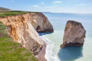 Scenic view of Freshwater Bay with its dramatic white cliffs and turquoise waters on Isle of Wight, England, a popular tourist attraction.